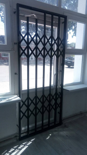 Раздвижная металическая решетка на двери окна витрины